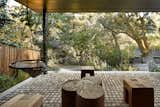 Shaded terrace with swing chairs and wood sculpture pieces