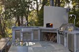 An outdoor kitchen with pizza oven is conveniently located adjacent to the interior kitchen