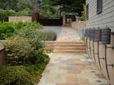 Outdoor, Side Yard, Stone Patio, Porch, Deck, Shrubs, and Metal Fences, Wall A welcoming and sophisticated path from the entry court  Photo 8 of 15 in On the Edge by Randy Thueme Design