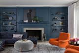 Living Room with tone-on-tone navy walls and and accent chairs upholstered in Hermes fabric.