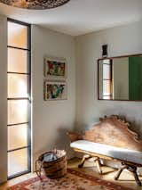 Centerpiece of the entry is an Art Nouveau carved wood bench attributed to Antoni Guadí; the ceiling fixture was made in France in the 1930s.
