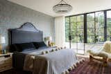 Primary bedroom; custom black metal headboard relates visually to steel casement doors that open to the outdoor deck.