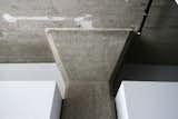 An exposed concrete column divides the volume of the kitchen and the one for the bathroom. The 12-foot ceilings still show the impressions of the stringers used for the building's formwork .