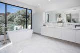 An elegant bathroom with standalone tub overlooks the hills.