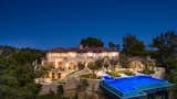 Situated atop a secluded canyon, the home boasts incredible outdoor space with multiple terraces and patios for grand-scale entertaining.