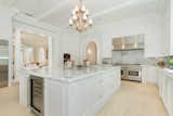 The magnificent chef’s kitchen showcases custom cabinetry, stacked Wolf appliances, and a large eat-in island, with doors off the breakfast area offering a gracious flow to the gardens. 