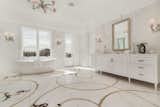 Refined marble floors and a standalone soaking tub in one of two master bathrooms.