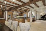 A staggering chef's kitchen is heightened by exposed wood beams and limestone floors.