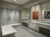 The elegant master bathroom features a soaking tub and Carrera and Bardiglio marble shower, floors and vanity.
