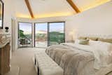 The voluminous master suite includes a fireplace, vaulted and exposed beam ceiling, and gracious terrace.