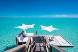 An above-water sun deck suspended over the turquoise-blue waters of Turtle Tale is primed for sunning and relaxing.