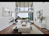 A striking, pivot front door opens to a soaring great room showcasing 24-foot ceilings and a seamless indoor-outdoor connection that persists throughout the entire residence.