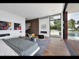 A lower level bedroom with fireplace provides seamless access to the pool deck beyond.