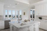 The sophisticated, chef-caliber kitchen with large marble center island and ocean-view dining nook.
