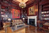 A refined, wood-paneled library with fireplace serves as an alluring retreat.