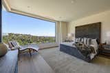 One of two sweeping master suites boasts large picture windows revealing views of the lush hillsides beyond. 