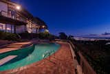 The city lights sparkle from the pool terrace.