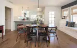 The open living room and chef's kitchen are filled with light and highlighted by charming Craftsman built-ins.
