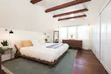 The generous upstairs master suite with vaulted ceilings and exposed beams.