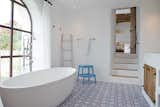 Mosaic tiles and a large soaking tub lend warmth to the spaces.