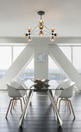 The geometric construction of the Bola suspension light gives this modern dining space bold contrast