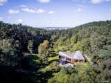 Valley Villa

Architectural firm Arches has recently created a contemporary, eco-friendly villa within close proximity to Vilnius, the capital of Lithuania and the country’s largest city. Clad in 7,000 sq. ft. of sustainable Kebony wood, this unique property has been built to complement the scenery, with natural timber cladding and irregular pitched roofs, characteristic of the neighbouring surroundings and in harmony with the hillsides and pine trees. The villa strikes the perfect balance with an architectural style that is simultaneously modern and traditional.

The clean, angular design creates a minimalist exterior with Kebony as the prime material contrasting against the black slate at the building’s base. Architect, Arūnas Liola, aimed to design a structure that is both ecologically friendly and striking in appearance, interweaving natural materials with a bold sculptural form.  The firm has frequently chosen to work with Kebony due to the fact that it is a natural material but with the resistance to stand up to testing conditions far better than softwood. The quality of the wood, and through the skills of an exceptional carpenter, meant the timber could be sculpted and worked with easily for this particular project. Kebony requires no additional treatment even when used as an external cladding, the material simply develops a silver-grey patina which will allow the house to adapt naturally to its surroundings over a period of time. 

The patented Kebony technology is an environmentally friendly process, which modifies sustainably sourced softwoods by heating the wood with furfuryl alcohol - an agricultural by-product. By polymerizing the wood’s cell wall, the softwoods permanently take on the attributes of tropical hardwood including high durability, hardness and dimensional stability, without the need for tropical deforestation, resulting in a high performing, beautiful wood product. 