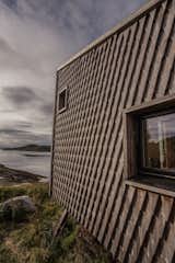 The artist’s retreat, founded by Norwegian composer and musician Håvard Lund, provides a tranquil haven to focus on creative pursuits. Completed in August 2016, the retreat, aptly named Fordypningsrommet or ‘room for deeper studies’ started out with just six mono-functional Kebony clad houses.  Growing demand has since led to the completion of three more buildings and now the retreat can accommodate up to 12 guests. 

Situated north of the Arctic Circle on the stunning island of archipelago Fleinvær, which encompasses between 200 and 300 islands, the artists’ retreat blends seamlessly into the surrounding rocky landscape. Each house is built on top of angled steel feet which creates a dramatic effect through the use of sharp lines and angles. The stylized architecture provides each house, consisting of a sauna, kitchen house, studio, bath house, sleeping houses and the so called Njalla or ‘tower for big thoughts’, with a degree of individuality. The exposed position of the retreat on the picturesque coastline provides a dramatic and ever-changing backdrop, with crisp coastal breezes bringing in the morning to the tranquil majesty of the Northern Lights illuminating the night sky.

This stunning setting is sure to inspire tranquillity and lend intensity to both recreational and artistic pursuits of its vacationers. On a self-catering basis, groups of up to 12 people are welcome to visit for a week for the price of $4,500 while artists wishing to stay for free at the retreat must be approved by a committee of three comprising; Musician, Nora Taksdal, Director, Katrine Strøm and General Manager, Håvard Lund. Those who are successful are required to pay for their travel to Bodø, however, beyond that everything in their stay is free of charge. At the end of their stay artists are invited to display their work at a public meeting which takes the form of a pre-show or lecture to the other artists staying on the remote island. This aspect of sharing knowledge is an integral part of the ethos at the retreat, and the architectural workshops conducted there have inspired students from all over the world, enabling them to acquire additional skills from preparing food to learning to fish. 

The retreat is intended to be a return to nature as well as an artistic endeavour, and as such there has been a strong emphasis on sustainability throughout. Kebony, the sustainable alternative to tropical hardwood was carefully selected as the cladding material for each house. The Kebony technology uses an environmentally friendly process, which enhances the properties of sustainable softwood with a bio-based liquid derived from agricultural crop waste. By polymerizing the wood’s cell wall with furfuryl alcohol, the wood gains greatly improved durability and dimensional stability, similar to the characteristics of tropical hardwood. Shortly after installation started, the Kebony wood has begun to develop a delicate silver patina, as it weathers naturally. The dappled silvery tones of the wood give the buildings a truly natural aesthetic as they perfectly complement the surrounding and unspoilt scenery. 
