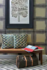 Repetition of pattern and color can provide unexpected highlights. Zig-zag velvet pillows by Manuel Canovas sits atop a handmade wool dhurrie rug. The handmade woodblock print of a golden apple tree was made in Brooklyn by a local artist. 