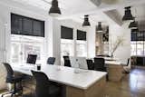 A touch of plant life successfully augments the simple black, white and wood scheme with natural beauty and contributes to a clean aesthetic.  Photo 6 of 13 in Small Office by SquareFoot