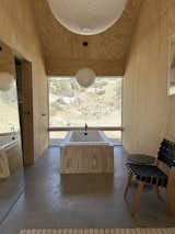 MAIN BATHROOM TUB - The main bedroom has an alcove with a freestanding tub in front of a floor to ceiling window looking out onto a desert cove.