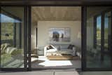 The guest house lounge spills out onto the outdoor living patio under the central canopy.