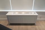 CUSTOM BUILT-IN RADIATOR COVER IN - CONTEMPORARY NYC RENOVATION: One of our custom built-in radiator covers conceals the apartment's new heating and cooling units, which were installed throughout the apartment. It's topped with gorgeous Caesarstone and inset with an access panel for maintenance and adjustment.