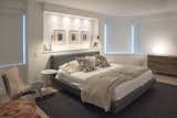 MASTER BEDROOM - CONTEMPORARY NYC RENOVATION: The big challenge in the master bedroom was the original unsightly soffit and structural beams to deal with. Our solution was to create a built in shelf behind the headboard with electrical outlets for reading lamps and recessed lighting above. It's the perfect place for books and highlighting art.