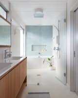 The primary bath has a separated zone for the tub and rainfall shower