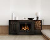 Minimalist cold rolled steel fireplace with integrated tool and wood storage.