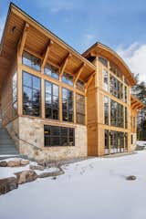 Stone and light wood siding paired with 3 story window facade