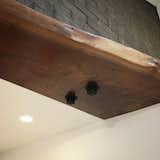 Live-edge walnut finish detail, used to obscure an unsightly metal support beam. Fantastic work by Michael Powell and Powell Woodworking.