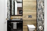 Bath Room, Marble Counter, Light Hardwood Floor, Drop In Sink, Recessed Lighting, Stone Slab Wall, and One Piece Toilet Fun powder room with the use of lots of pattern to complement the finish materials  Photo 3 of 4 in Kahn Apartment by Exint