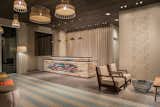 The center core of the space is the herringbone and sand cement tile surrounded by oversize concrete natural tiles.

The intention was  to bring the water and sand as a ripple directly into the lobby as you enter.