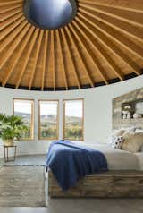 The ceiling of all three yurts is made with tongue-and-groove planks of Douglas fir that meet at a steel skylight at the center. A custom-made bed is complete with a linen duvet cover from Coyuchi and enticing sheepskin pillows. 