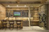 Satin Black Wall Series wine racks are attached to a rustic stone wall in this Vail, Co, area basement bar.