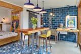 Basement guest suite. Finished the basement. Was a damp space with the boiler prior. Popham tile inlay, Heath 6x12 tile on wall, vintage lighting, original concrete utility sink- copper plated the legs, redwood table by Surfridge, vintage prints. 