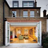 Storage, Wall Mount Sink, Shelves, Bed, Table, Sofa, Light Hardwood Floor, Living Room, and Recessed Lighting  Photos from Bright Bauhaus Colors Fill This Brick Edwardian House in London