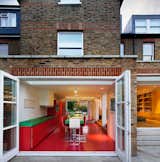 London architecture studio AMA remodeled this home in an old Edwardian building with bold Bauhaus colors, and transformed the kitchen into an audacious red and green space with glossy vermillion floors.