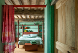 Bedroom, Bed, Bench, and Medium Hardwood Floor  Photo 2 of 10 in Rustic Meets Modern In This Tuscan Village Boutique Hotel