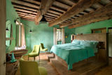 Bedroom, Wall Lighting, Chair, Bed, and Medium Hardwood Floor  Photo 10 of 10 in Rustic Meets Modern In This Tuscan Village Boutique Hotel