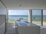 Trees, Sofa, Grass, Back Yard, Wood Burning, Coffee Tables, Concrete, Metal, Kitchen, White, Recessed, Wall Oven, Undermount, Refrigerator, Light Hardwood, and Cooktops  Kitchen Trees Concrete Refrigerator Wall Oven Undermount Cooktops Photos from An Architect's Big “Little Cottage” That You Can Rent on the South  Coast of Cornwall