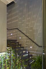 Wood Patio, Porch, Deck, Metal Tread, Table, Ceiling Lighting, Sofa, Gardens, Bed, Shelves, Dark Hardwood Floor, Rooftop, and Staircase  Photo 2 of 6 in stairs with metal bar by christine clements from This Modern Home in Singapore Is a Living Urban Jungle