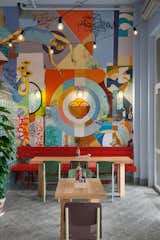 A vibrant and eclectic 65-seater diner in Kiev, Ukraine that serves Asian street food, Kitaika designed by AKZ Architectura was inspired by street culture in Asia and Ukraine. Combining carnival-like elements, bold colors, garlands of exposed light bulbs, and eye-catching graffiti, this little diner is a surreal and delightful take on Asian dining.