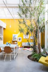 A cozy kitchen-dinning area in the studio and home of an Antwerp artist couple with Eames chairs, a second hand sofa and mustard-yellow walls.  Photo 10 of 10 in 9 Small Spaces With  Color